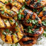 Hawaiian Chicken with Coconut Rice topped with grilled pineapple and fresh parsley, glazed chicken served over fluffy rice