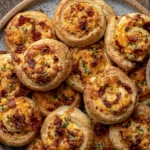 Crispy golden Jalapeno Popper Pinwheels served with creamy dipping sauce, topped with bacon and melted cheese