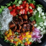 Jerk Chicken Buddha Bowl with Mango Salsa served with rice, fresh vegetables, and grilled spicy chicken