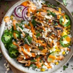 Street Corn Chicken Rice Bowls topped with grilled chicken, jalapeños, creamy corn, rice, and chipotle sauce drizzle