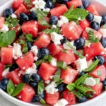 Watermelon Feta Salad with blueberries, fresh mint, basil, and crumbled feta in a serving bowl