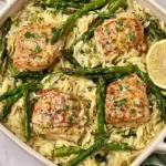 Creamy Orzo with Chicken and Asparagus baked in a dish with golden chicken, tender asparagus, and lemon slices