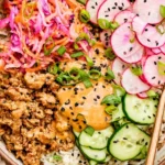Ground Turkey Rice Bowls with bang bang sauce, fresh cucumbers, radishes, shredded cabbage, and sesame seeds over white rice