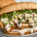 Chicken Chopped Sandwich with Alabama BBQ Sauce topped with crispy chicken, chopped lettuce, pickles, red onion, and creamy white BBQ sauce.