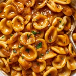 One Pot French Onion Pasta with caramelized onions, orecchiette, savory sauce, fresh herbs, and black pepper.