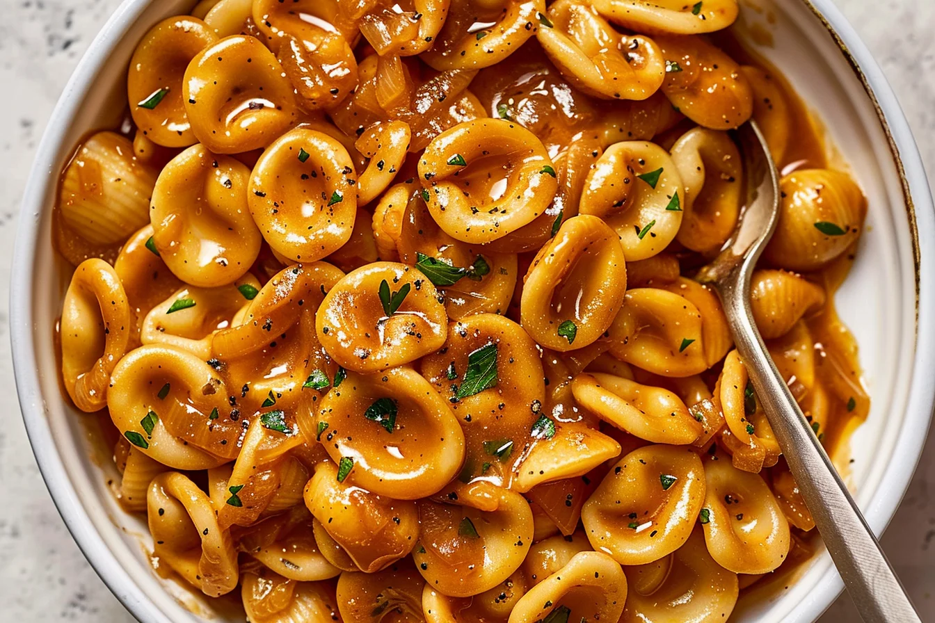 One Pot French Onion Pasta with caramelized onions, orecchiette, savory sauce, fresh herbs, and black pepper.