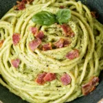 Avocado Carbonara with creamy avocado sauce, linguine, crispy bacon, black pepper, and fresh basil in a rustic bowl.