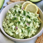 Herby Avocado Egg Salad with hard-boiled eggs, fresh dill, parsley, red onion, lemon, and creamy avocado in a serving bowl.