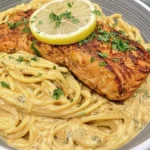 Creamy lemon garlic pasta and Salmon with golden pan-seared salmon, creamy Parmesan pasta, fresh parsley, and lemon.
