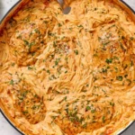 Creamy Tomato Orzo With Chicken in a skillet with tender seared chicken, creamy tomato sauce, and orzo pasta garnished with fresh herbs