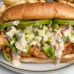 hicken Chopped Sandwich with Alabama BBQ Sauce featuring crispy fried chicken, romaine, pickles, red onion, and creamy white BBQ sauce.