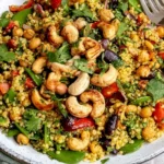 Curry Cashew Chickpea Quinoa Salad with toasted cashews, chickpeas, colorful vegetables, quinoa, and fresh herbs.