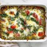 Quinoa Pesto Bake Dump & Bake with melted mozzarella, cherry tomatoes, basil, and pesto in a white casserole dish