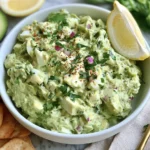 Herby Avocado Egg Salad with hard-boiled eggs, creamy avocado, fresh parsley, red onion, lemon, and herbs served with crackers.