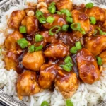 Peanut Butter Chicken with creamy savory peanut sauce served over fluffy white rice and topped with green onions and chopped peanuts.