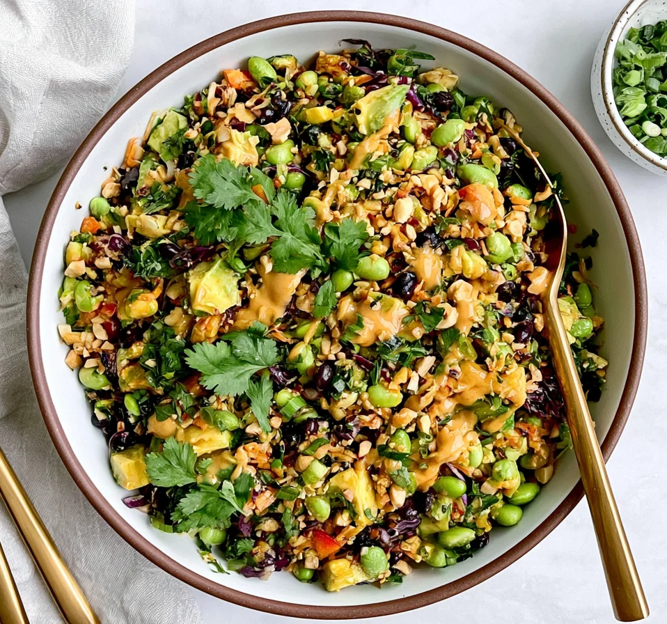 Edamame Peanut Crunch Salad with avocado, cabbage, kale, and creamy peanut dressing topped with chopped cashews