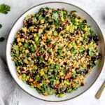 Colorful Edamame Peanut Crunch Salad with shredded cabbage, kale, carrots, and creamy peanut dressing topped with chopped nuts