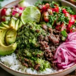 Ground Beef Chimichurri Bowls with rice, avocado slices, lime, fresh tomato salsa, and pickled red onions topped with vibrant chimichurri sauce
