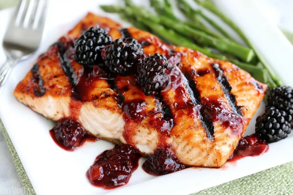 Grilled Salmon with Blackberry Sauce drizzled over grilled salmon fillet topped with fresh blackberries and served with asparagus