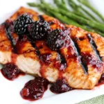 Grilled Salmon with Blackberry Sauce drizzled over grilled salmon fillet topped with fresh blackberries and served with asparagus
