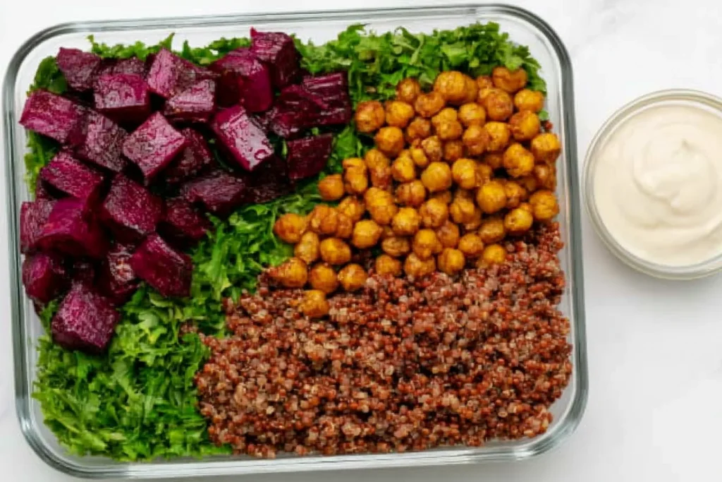 Quinoa Beet Bowls meal prep with kale, roasted beets, crispy chickpeas, and tahini dressing in glass container