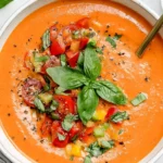 Easy Gazpacho Recipe with fresh tomatoes, cucumber, basil, and olive oil served chilled in a bowl