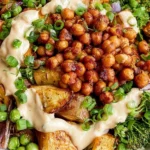 Roasted Potato Salad with BBQ Chickpeas featuring crispy golden potatoes, roasted broccoli, red onion, greens, and creamy tahini sauce.