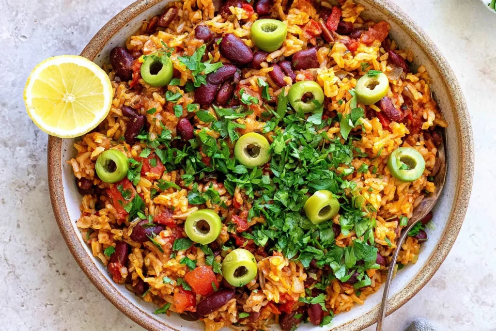 Spanish Rice and Beans one pot dish topped with green olives, parsley, and lemon, a hearty and flavorful meal