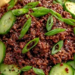 Korean Ground Beef with Cucumber Salad topped with green onions and sesame seeds in a bowl