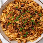 Honey Garlic Chicken Noodles with sticky sauce, ground chicken, and scallions in a bowl