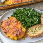 Very Veggie Lentil Bake served with fresh greens and garlic bread, featuring a crispy golden cheddar topping.