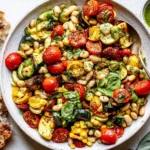 White bean salad with summer vegetables, grilled zucchini, corn, cherry tomatoes, cannellini beans, basil, and toasted bread.