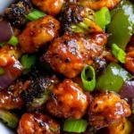 Black Pepper Cauliflower coated in a glossy pepper sauce with colorful vegetables and fresh green onions.