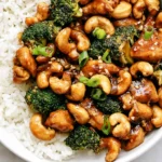 Cashew Chicken with broccoli, crunchy cashews, green onions, and white rice in a bowl