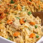 Chicken Noodle Casserole with tender chicken, creamy egg noodles, peas, carrots, and a crispy golden cracker topping.