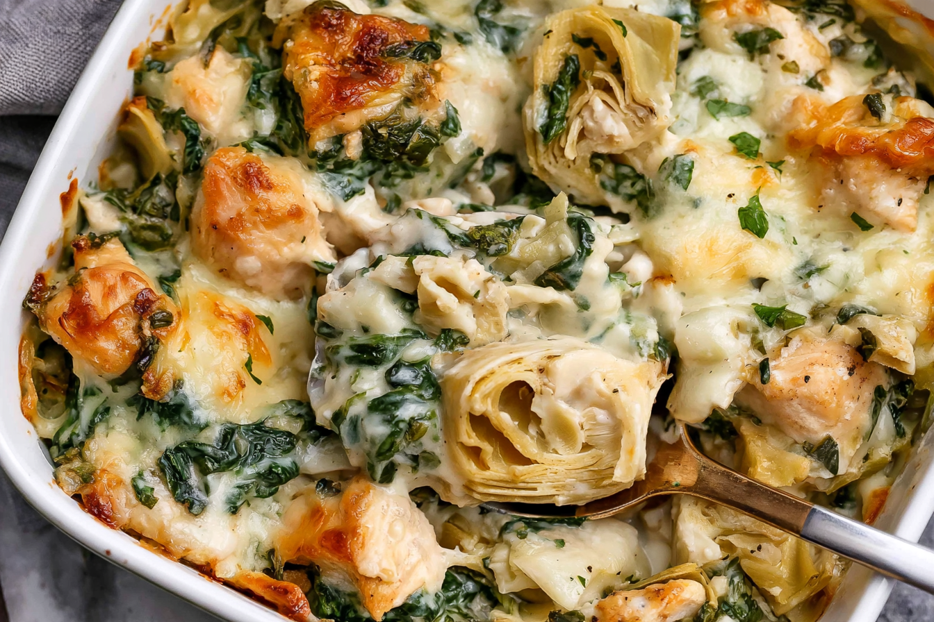 Spinach Artichoke Chicken Casserole with tender chicken, spinach, artichoke hearts, and golden melted cheese in a creamy sauce.