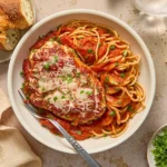 Spinach Ricotta Chicken topped with marinara and Parmesan, served with spaghetti and crusty bread.
