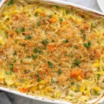Chicken Noodle Casserole with creamy egg noodles, tender chicken, peas, carrots, corn, and a golden crispy topping.