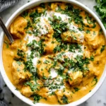 Slow Cooker Chicken Korma with tender chicken in a rich golden coconut curry sauce, topped with yogurt and fresh cilantro.