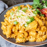 Slow Cooker Chicken Enchilada Pasta with tender chicken, rotini, creamy enchilada sauce, shredded cheese, and green onions.
