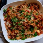Tikka Masala Rice Bake with crispy tofu, fluffy basmati rice, roasted peppers, onions, and fresh cilantro in a white baking dish