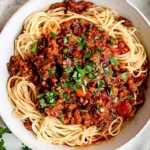 Vegan Lentil Bolognese with spaghetti, hearty tomato lentil sauce, fresh herbs, and red pepper flakes