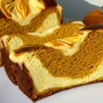 Pumpkin Cheesecake Bread slices with moist spiced pumpkin crumb, thick creamy cheesecake swirls, and a small pumpkin in the background.