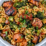 Chicken Sausage Broccoli and Orzo Skillet in a white bowl featuring golden-browned chicken sausage slices, tender broccoli, orzo pasta, and fresh herbs.