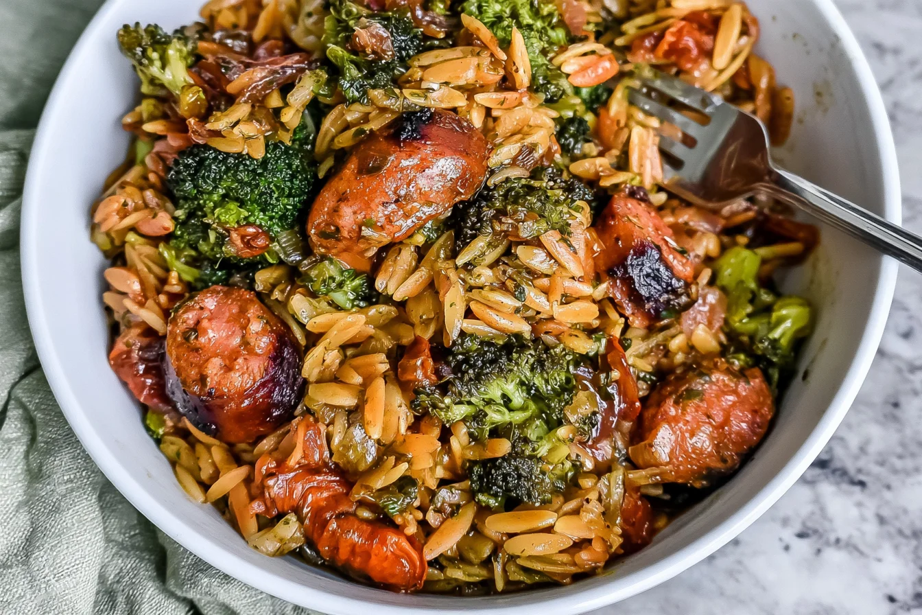 Chicken Sausage Broccoli and Orzo Skillet served in a white bowl with golden-browned chicken sausage slices, tender broccoli, and savory orzo pasta.